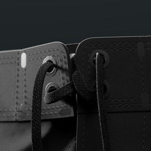 Close-up of a black leather belt with a buckle on a dark background