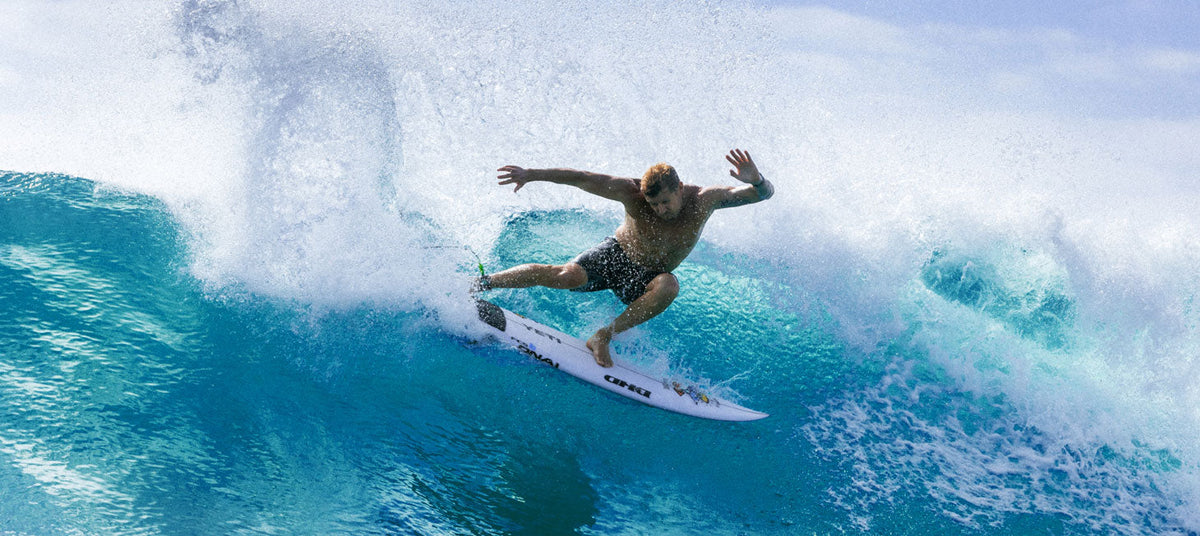 Mick Fanning surfing a wave on a clear blue day
