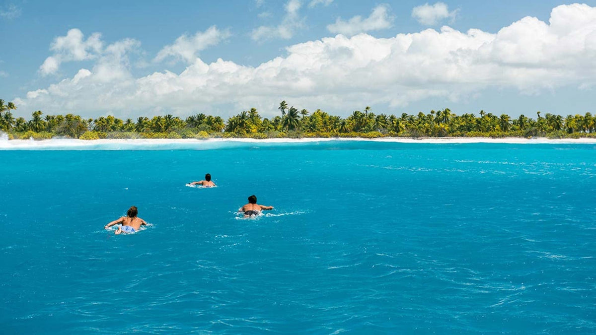 Surfers paddling out
