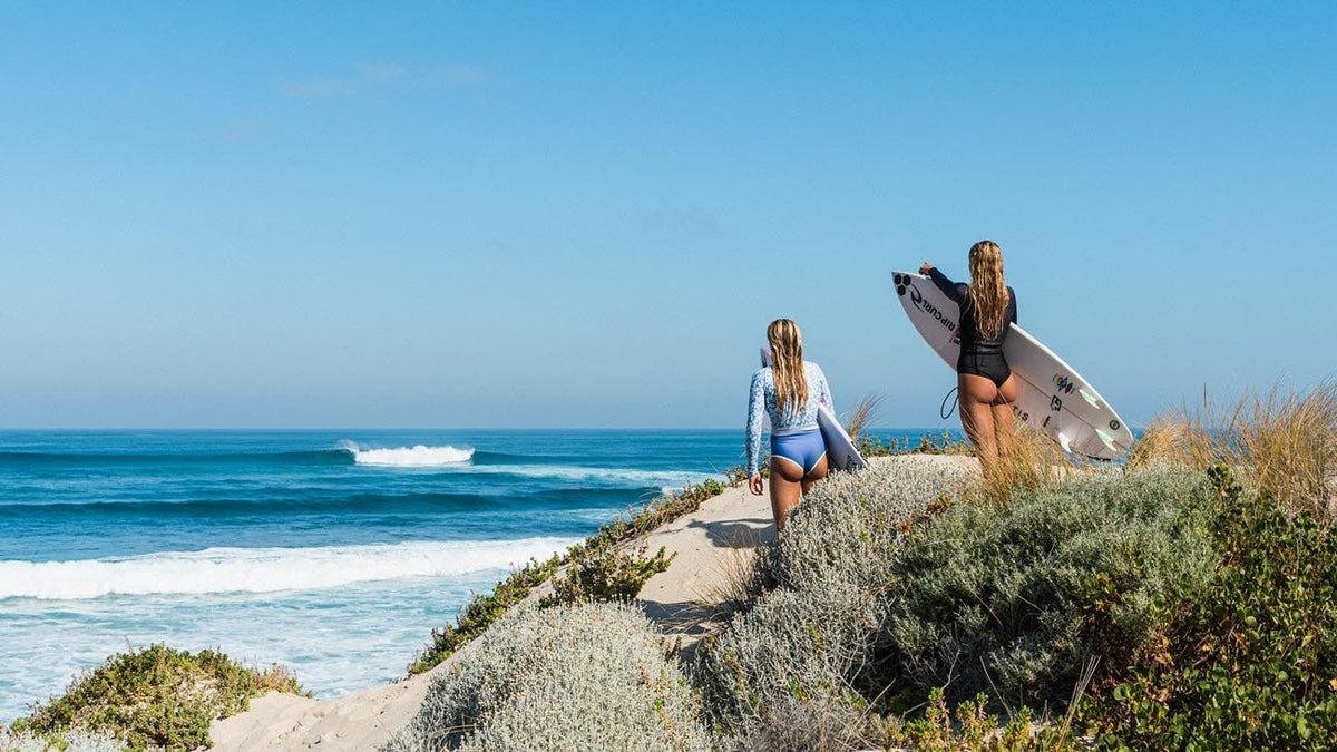 Two surfers on rocks in Western Australia