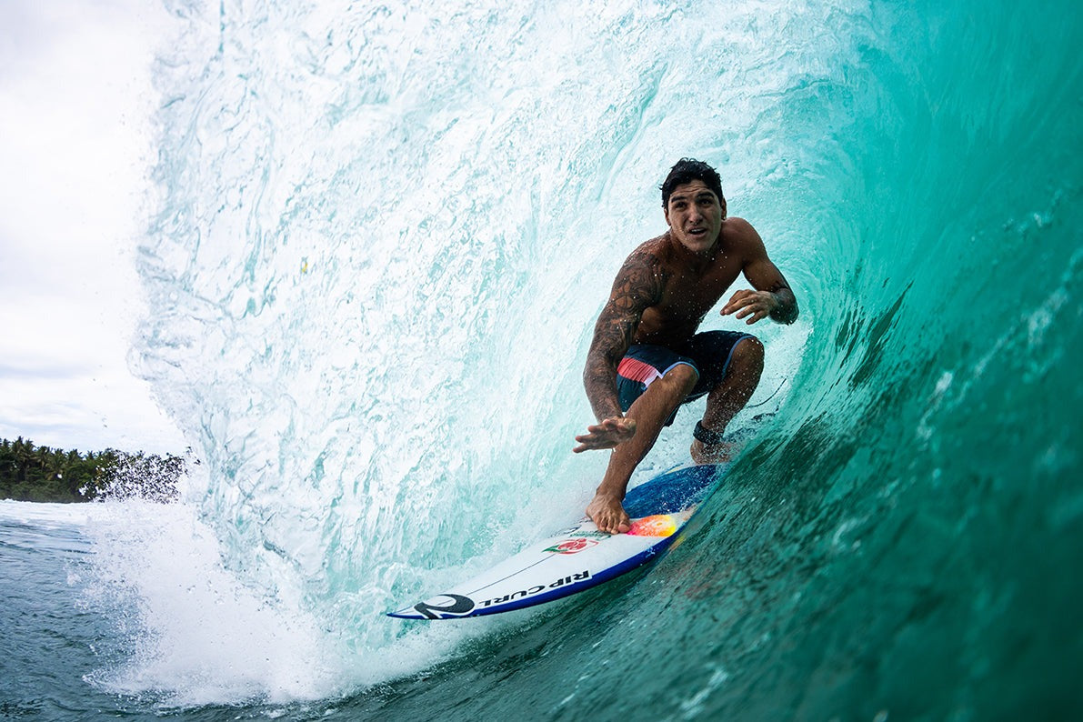 Surfer riding a wave in a clear blue ocean