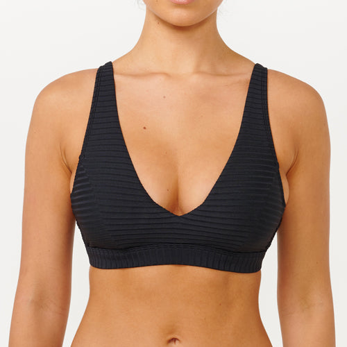 Black ribbed sports bra worn by a person on a white background