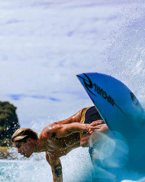 Person surfing with a blue surfboard in the water