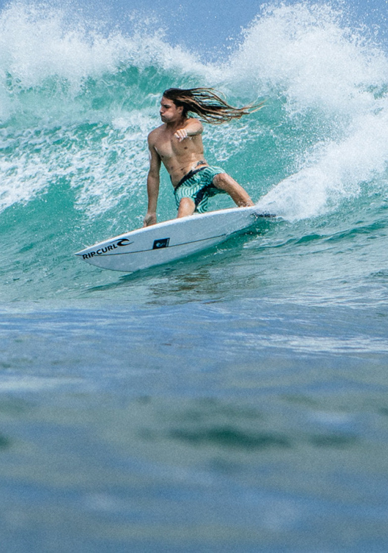 Person surfing on a wave with a Rip Curl surfboard