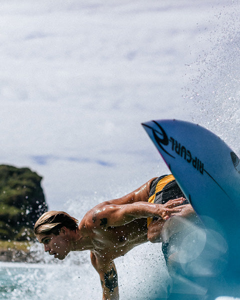 Person surfing with a blue surfboard in the water