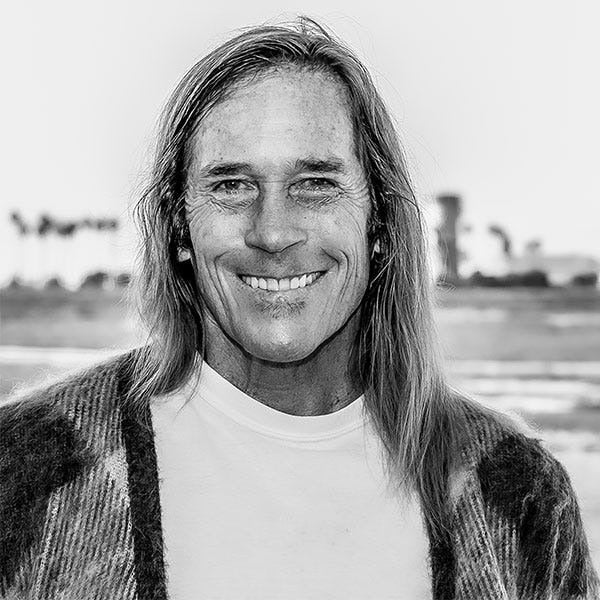Black and white photo of a person with long hair and a checkered shirt.
