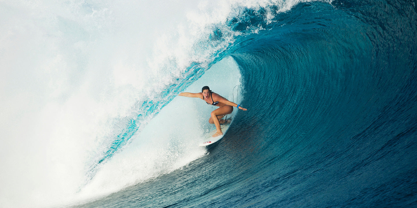 Person surfing a large wave in the ocean