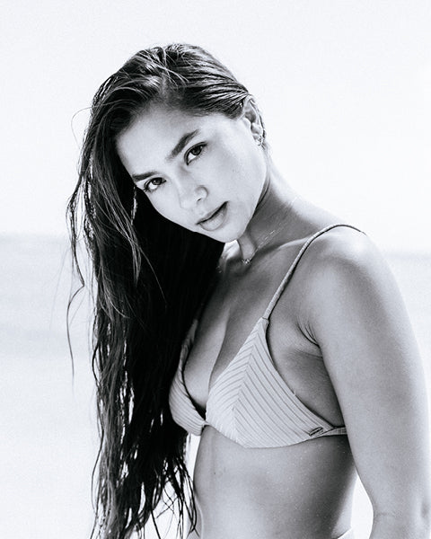 Black and white photo of a woman wearing a bikini.