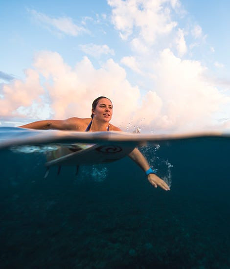 mid water view of the woman on a surfboard