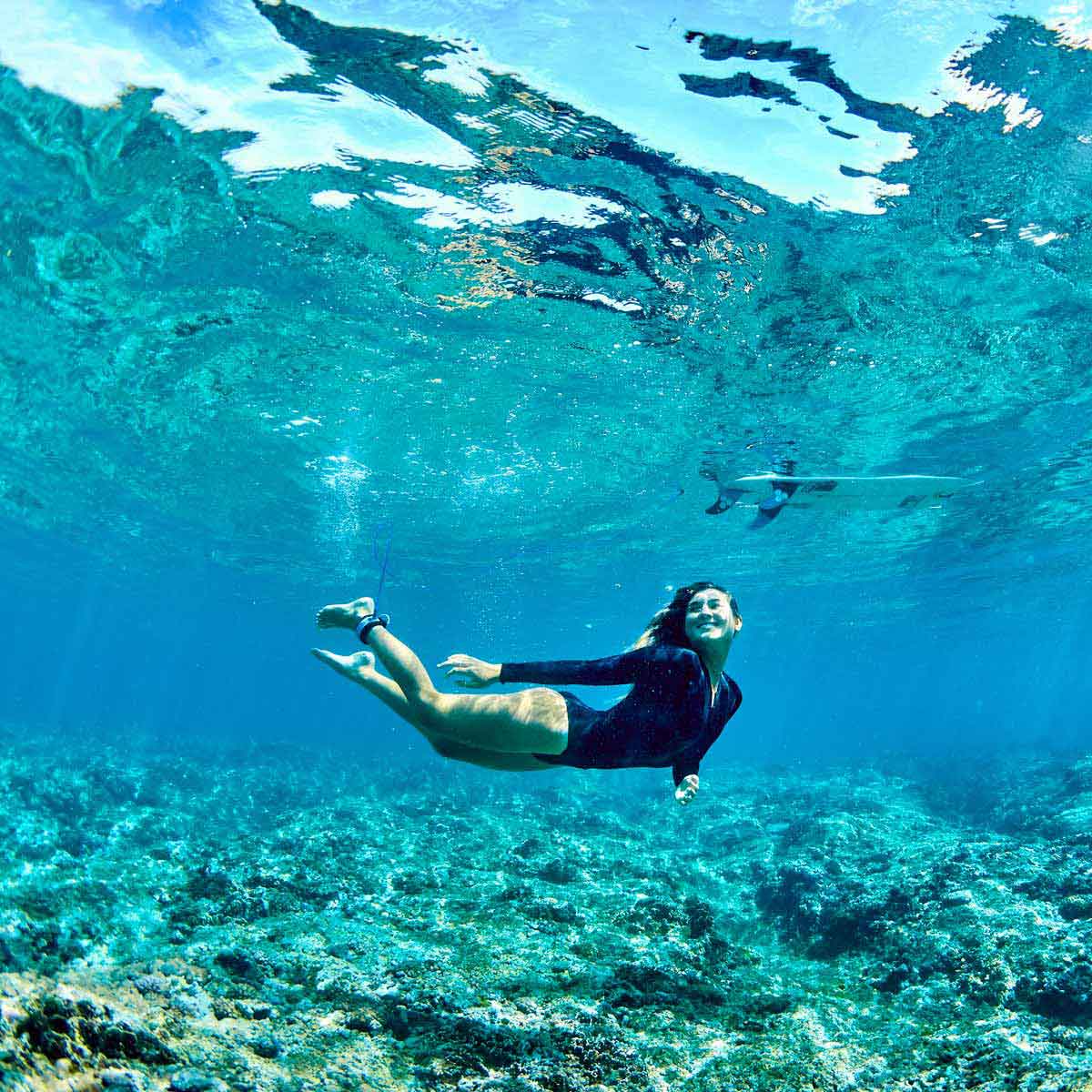 Brisa Hennessy duck diving under a wave in Fiji