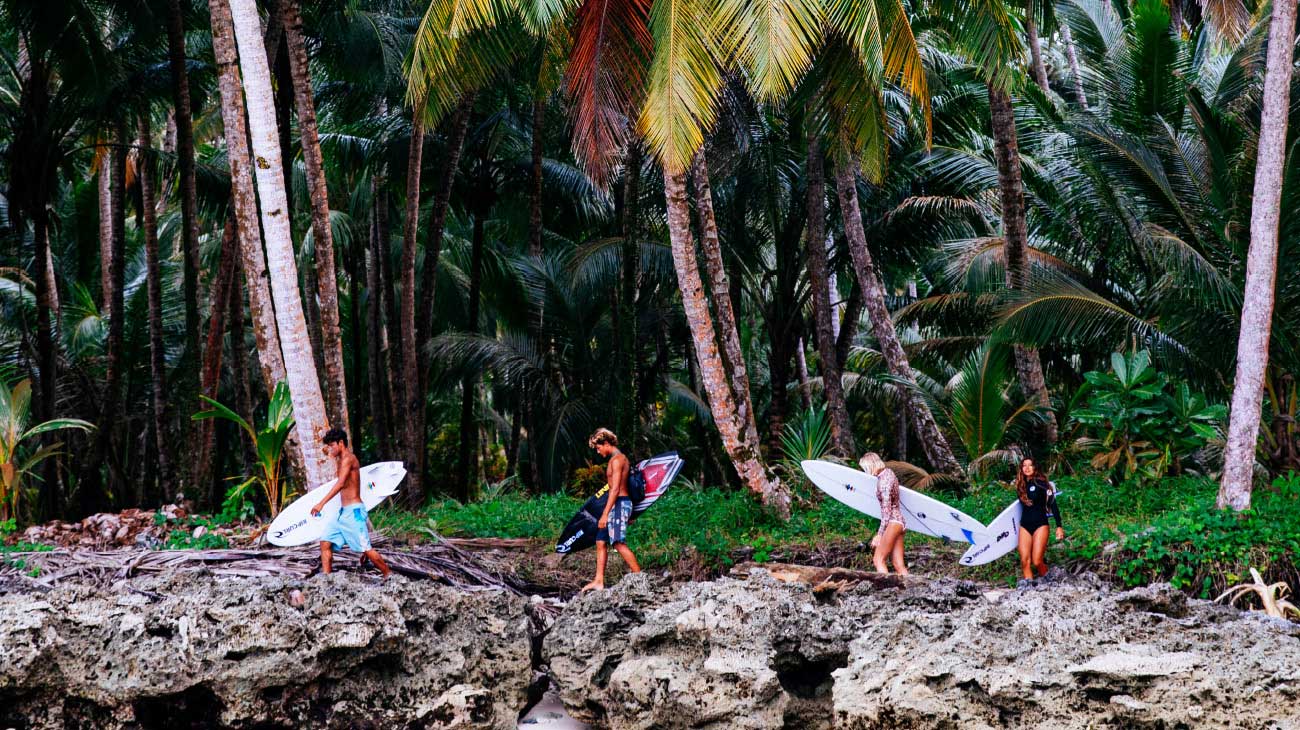Crew walking across rocks in the Mentawais