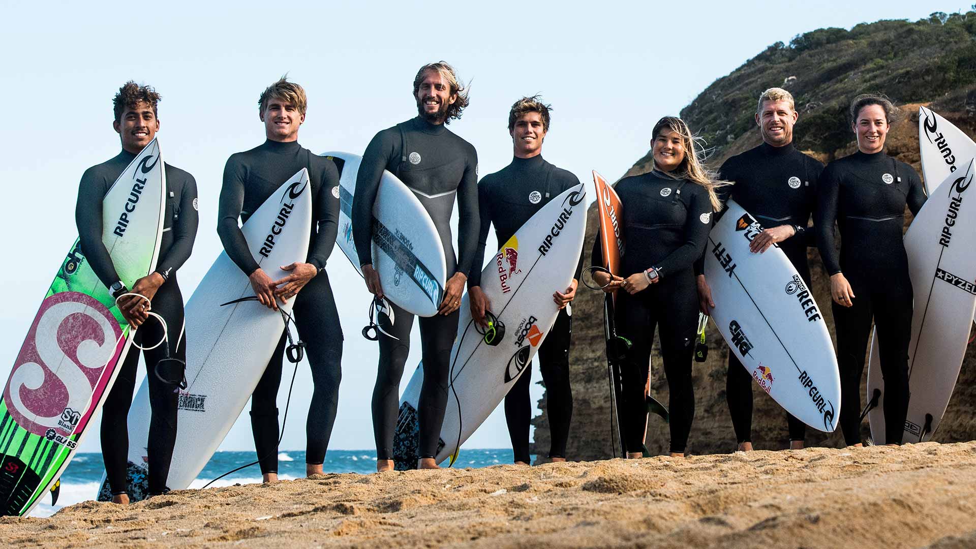 Rip Curl team riders standing with their boards on the famous Bells Beach