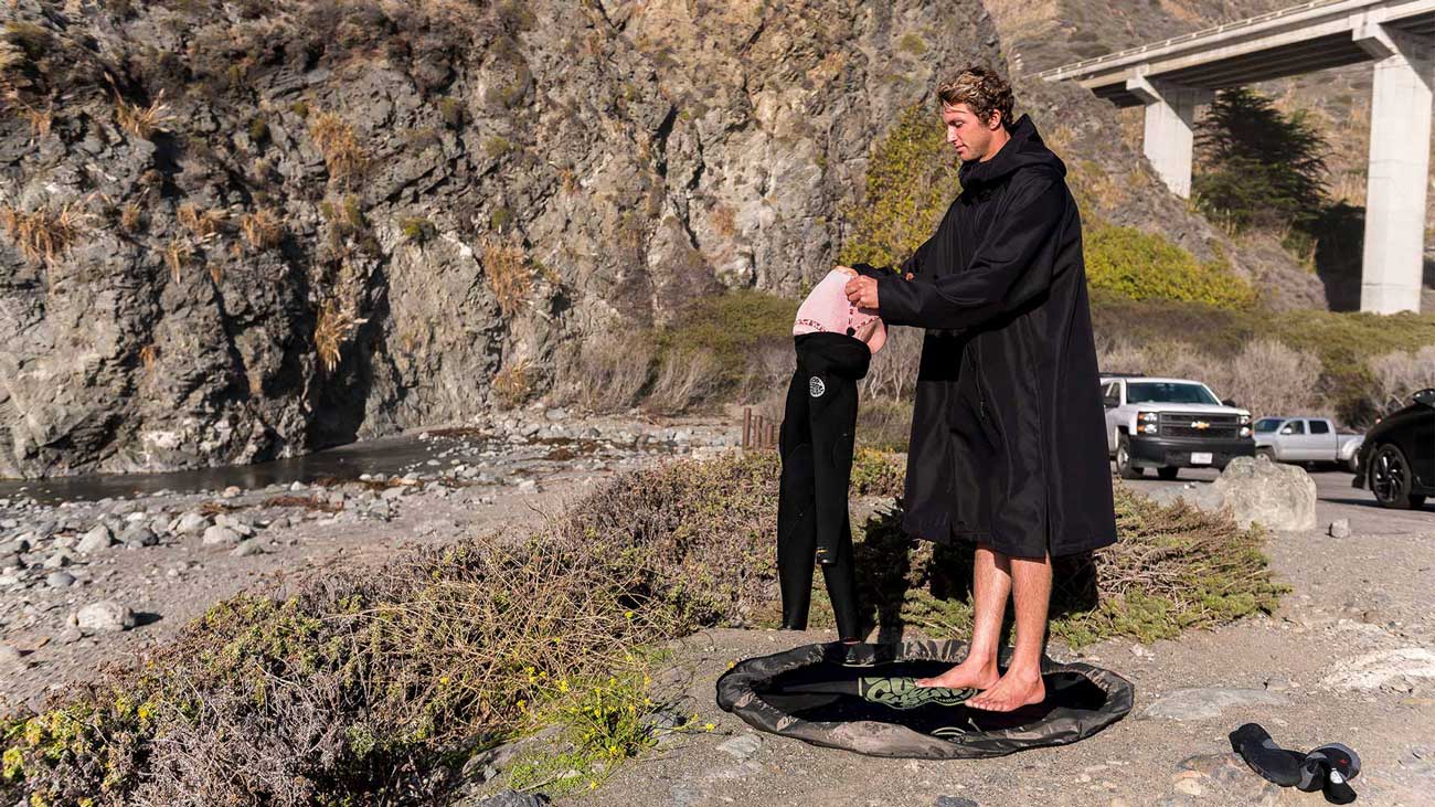 Surfer Conner Coffin hanging up his E-Bomb Rip Curl wetsuit and booties to dry after a surf