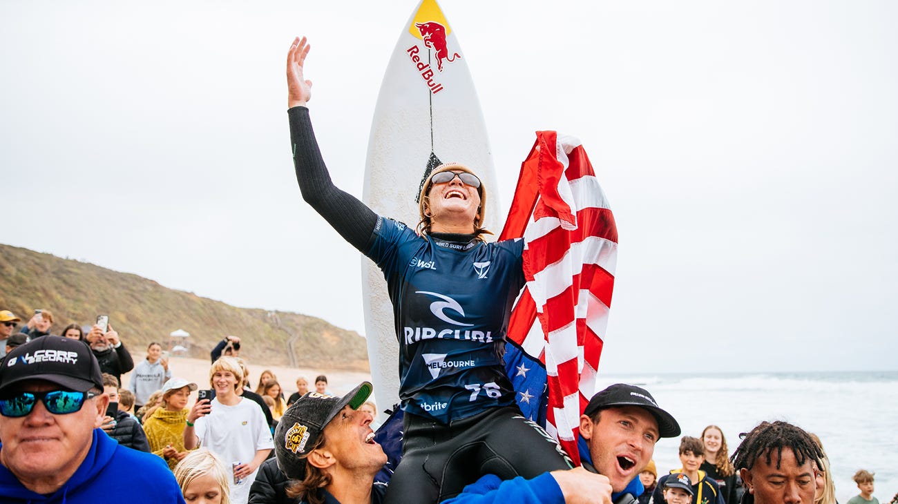 Caitlin Simmers being chaired across the beach after her win