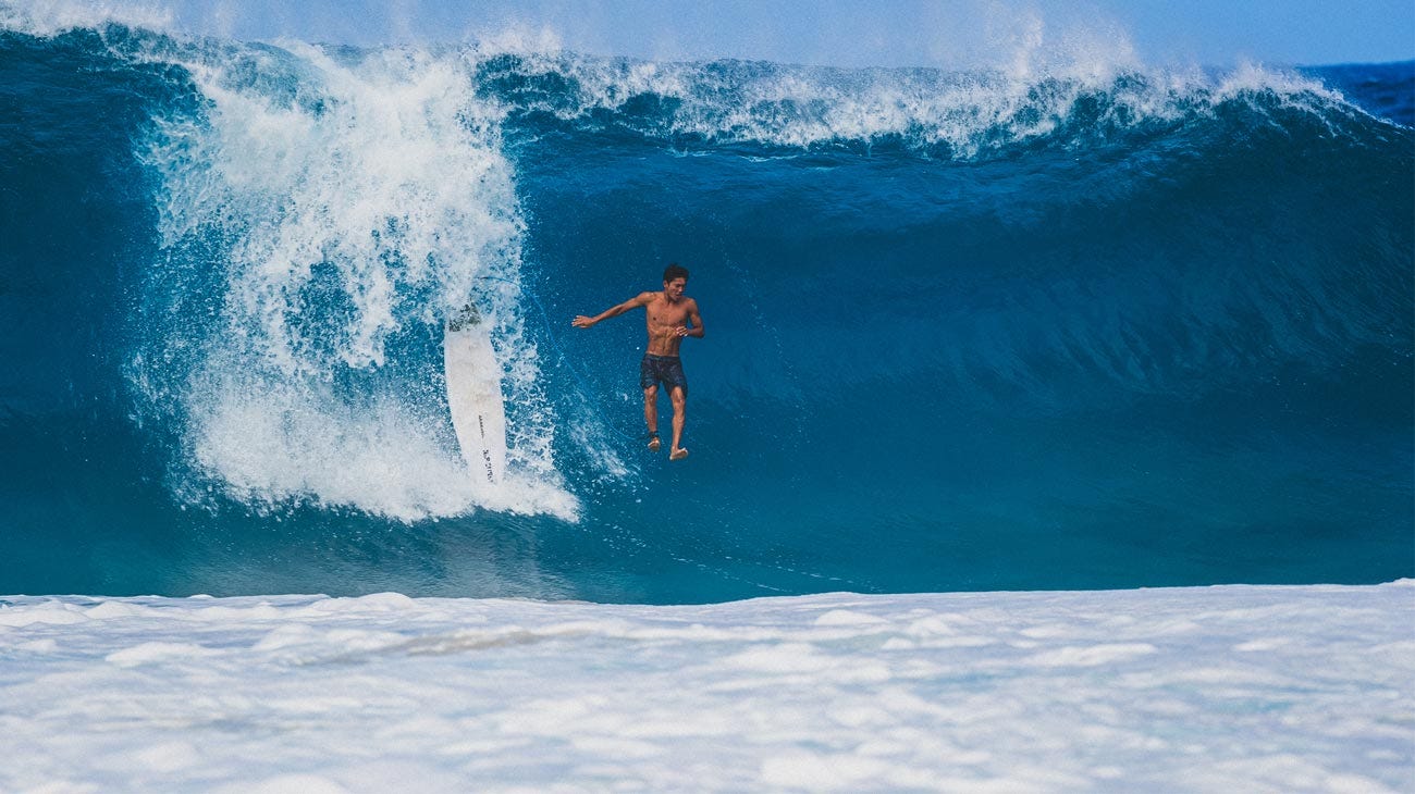 Crew jumping off his board off a wave