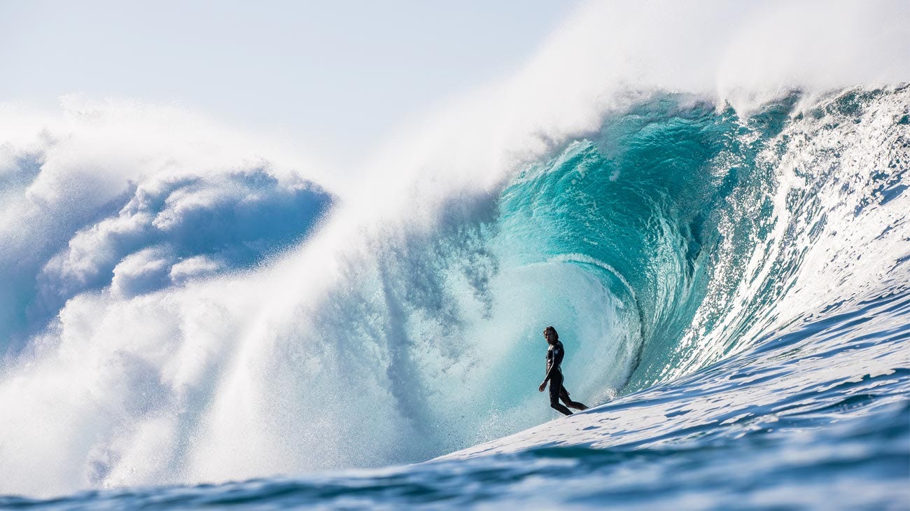 Kipp Caddy standing up in a barrelling wave in Tasmania