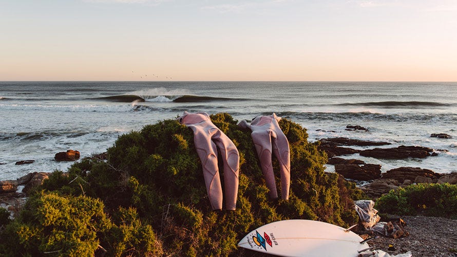 Wetsuits drying on a rock on the beach