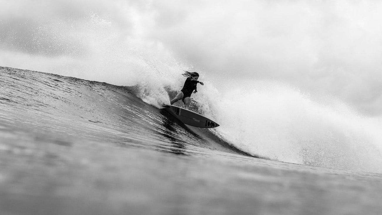 A black and white image of Stephanie Gilmore freesurfing 