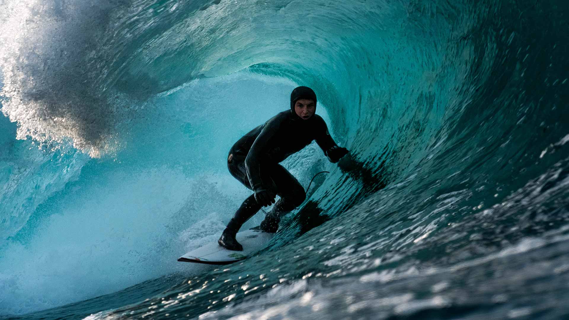 Mason Ho wearing a full wetsuit, hood and booties