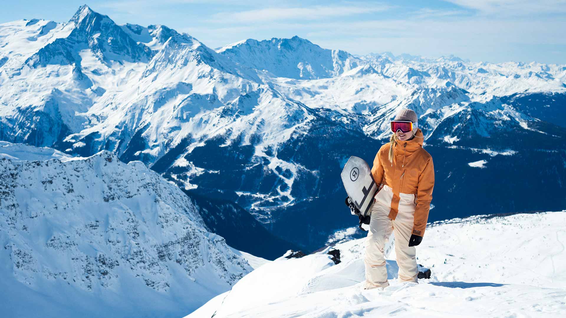 Rip Curl team snow team rider holding their snow board in the Alps