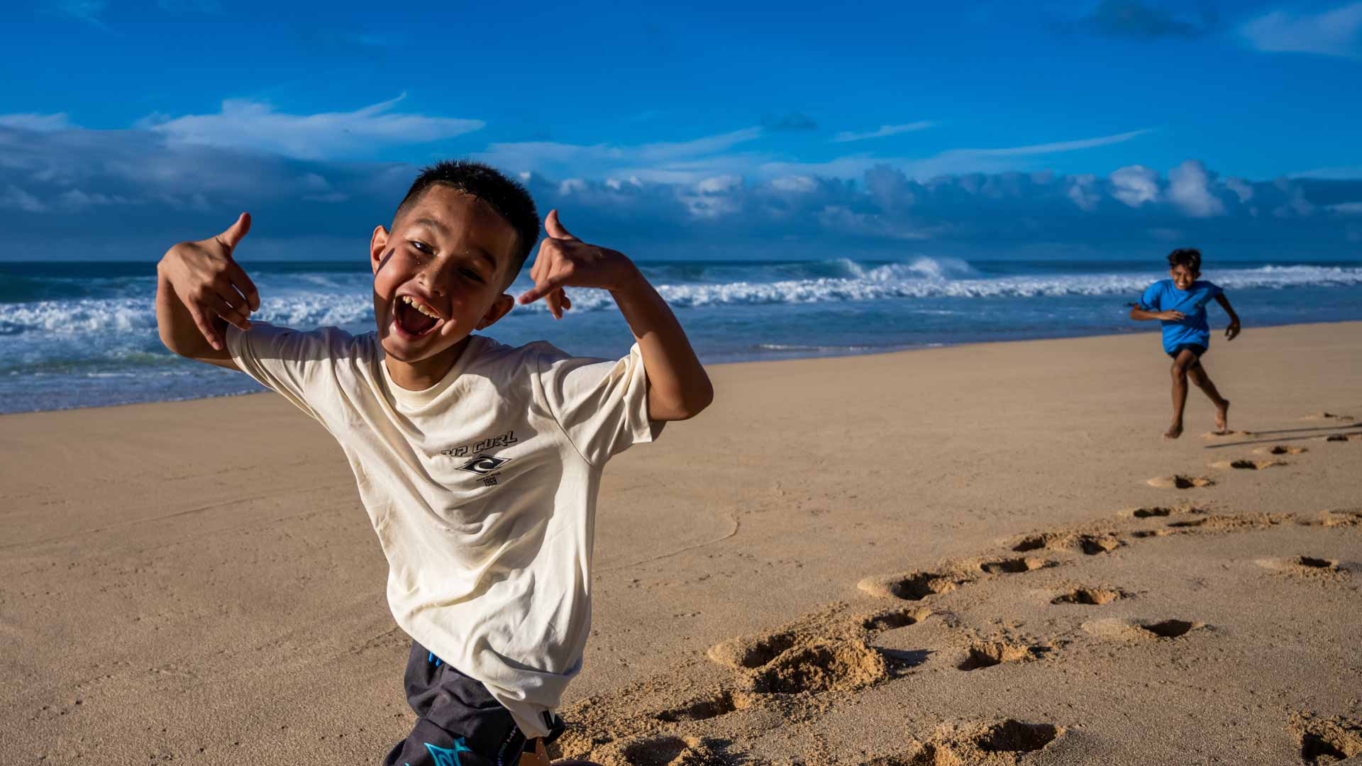 Rip Curl groms throwing shaka's on the beach in Hawaii.
