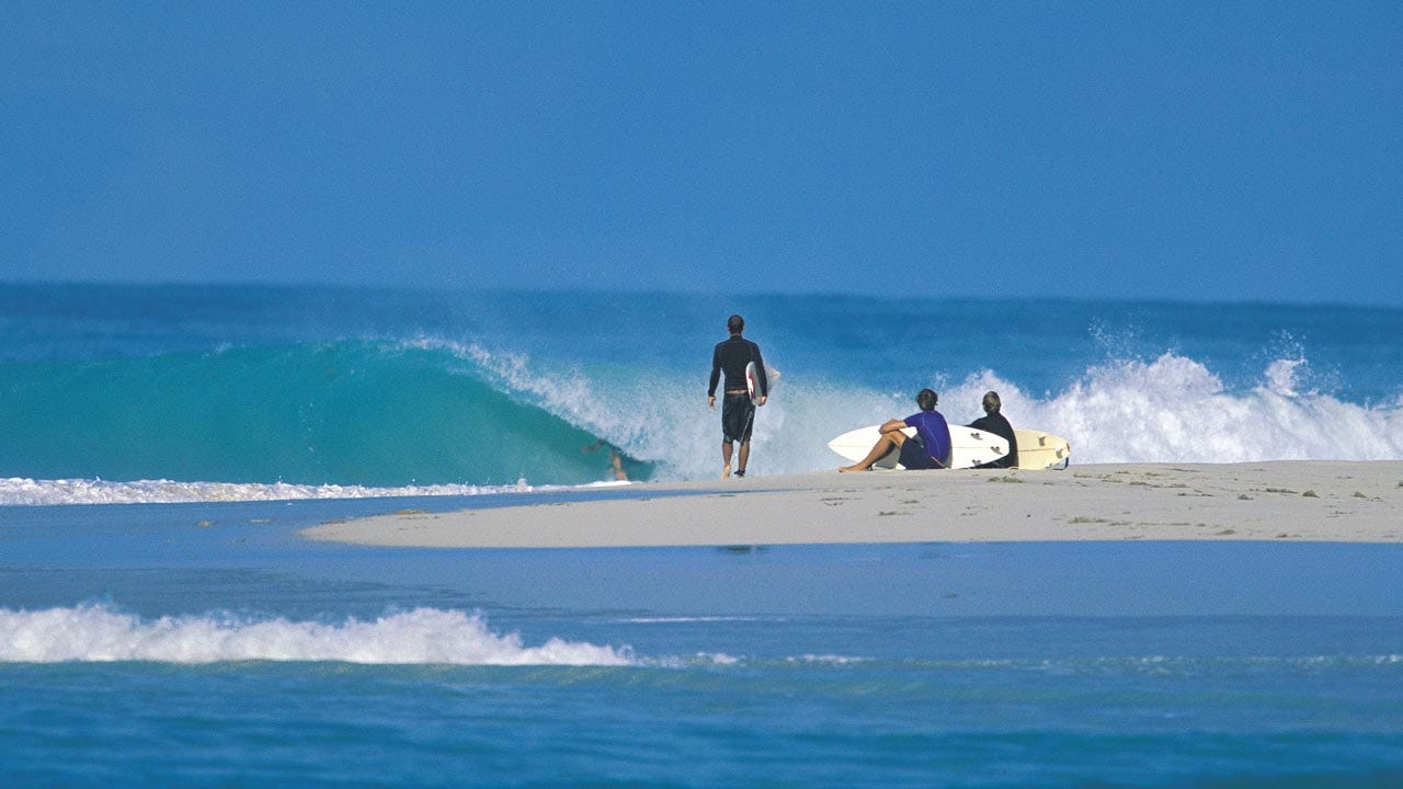 People sitting on the beach waving waved in Jamaica
