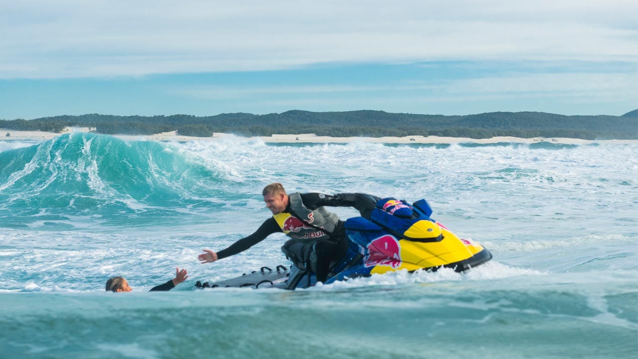 Mick Fanning helping Molly Picklum up onto a jetski