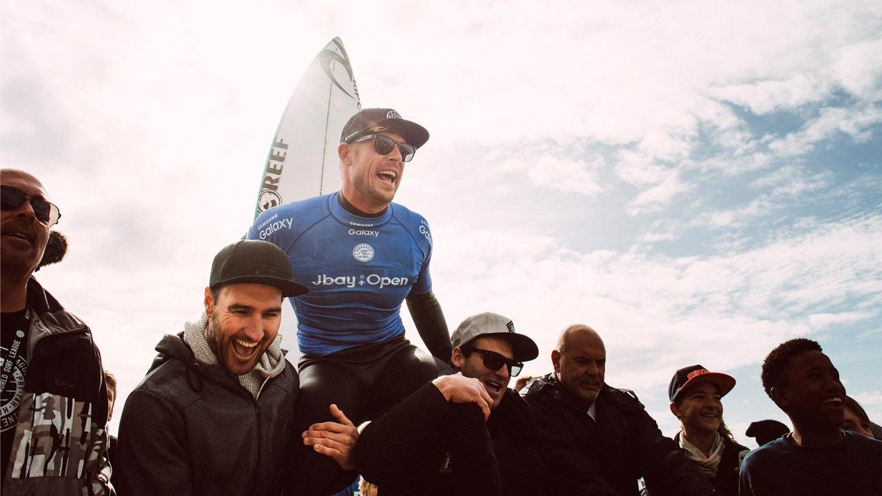 Mick Fanning being chaired by friends after winning J-Bay in 2016