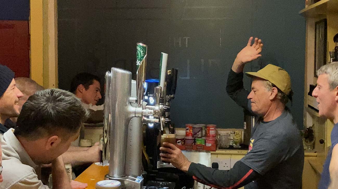 Tom Curren serving beers in a bar in Ireland