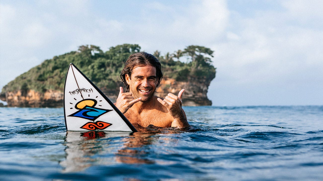 Mason Ho sitting on his board in the water