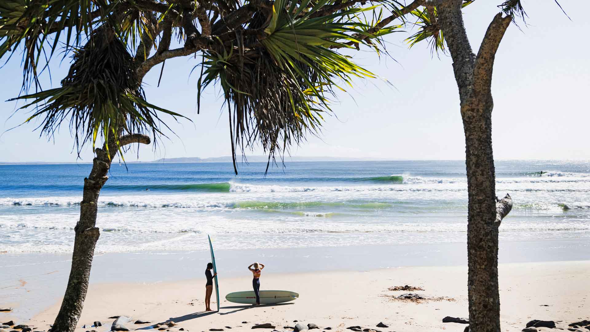 Female Surfers on the beach with their surfboards in Noosa, Australia.