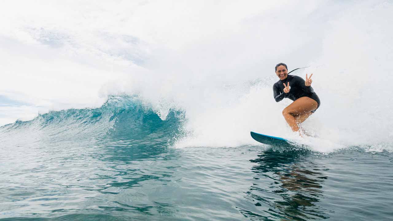 Rip Curl team rider surfing in fiji throwing peace signs