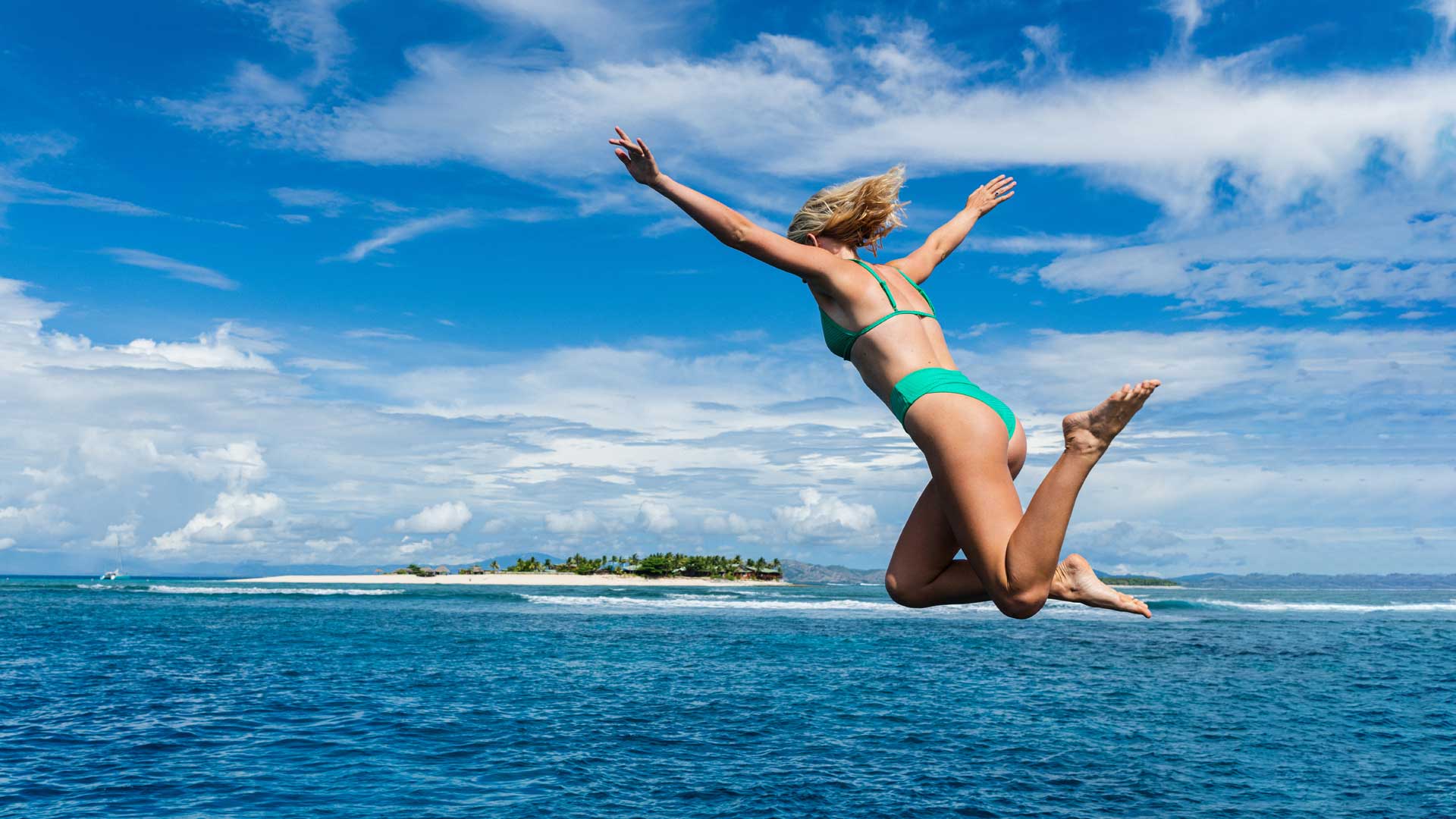 Mason Schremmer jumping off a boat in Fiji