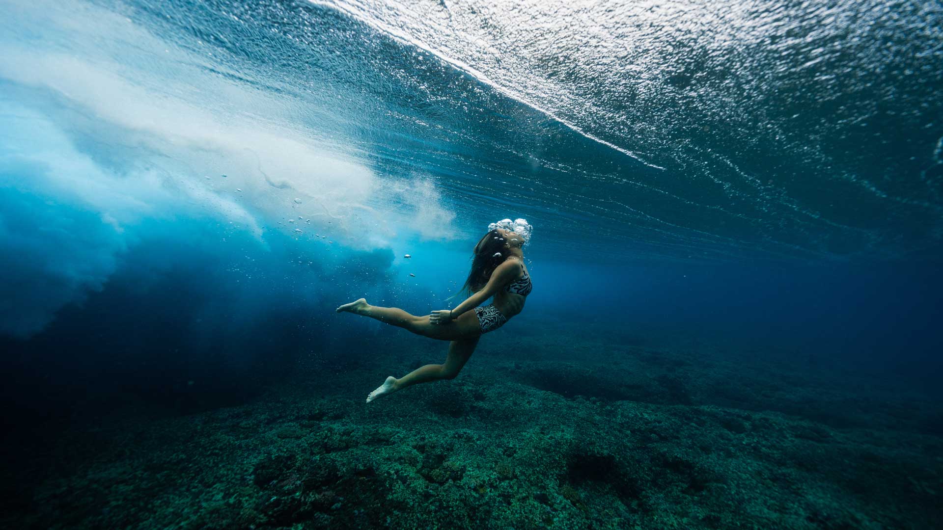 Rip Curl womens team duck diving under the water