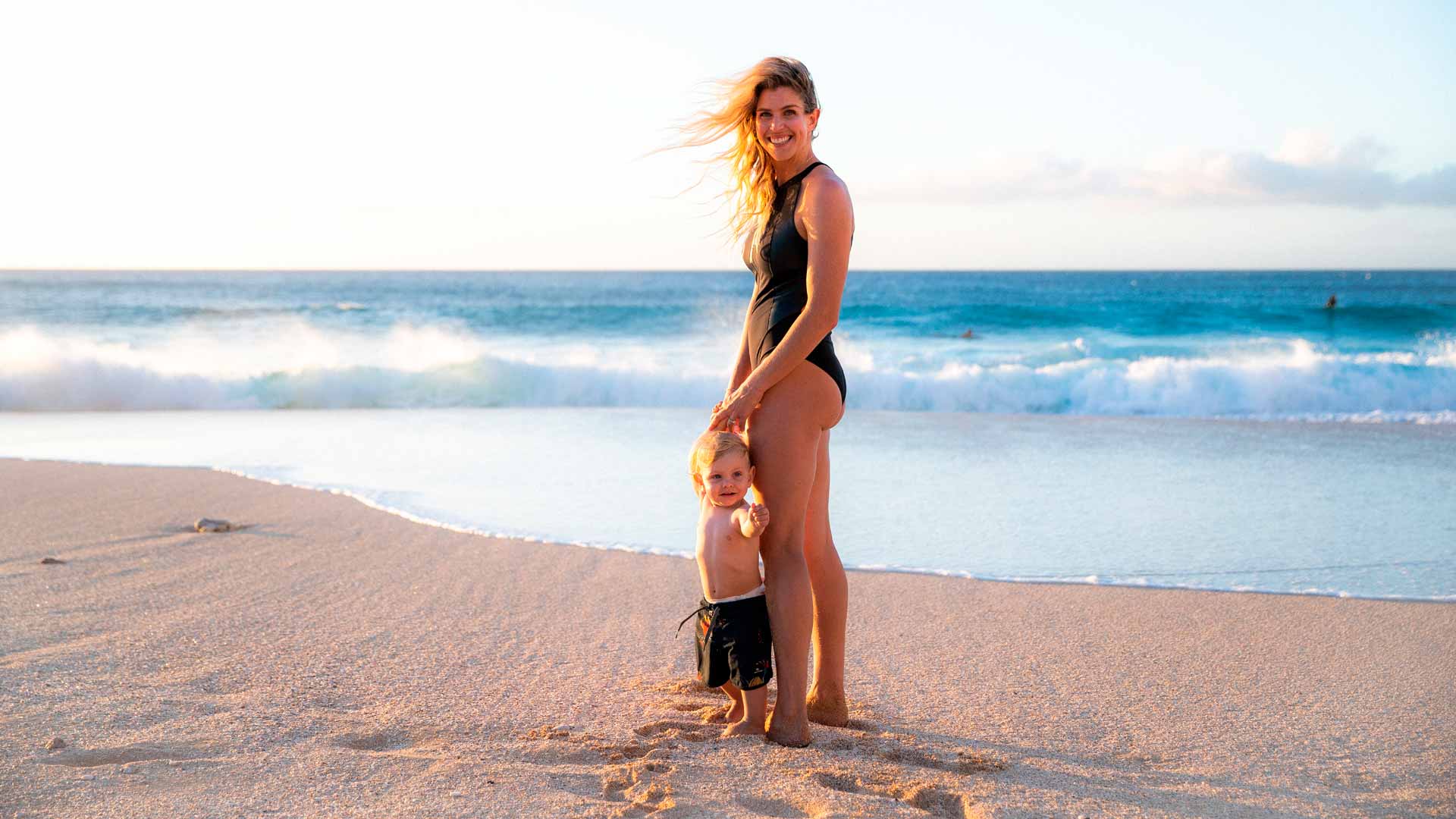 Rosy Hodge standing on the beach with her son.