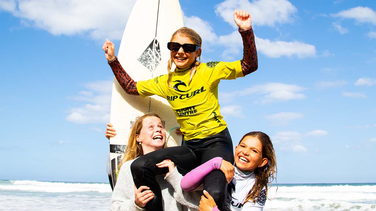 Scarlett Rennie being chaired along the beach by her friends