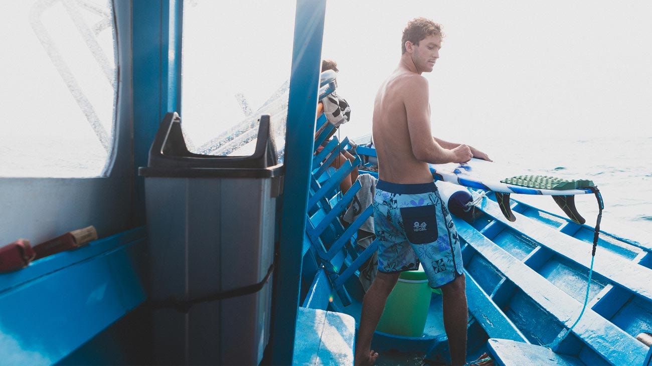 Crosby Colapinto waxing his surf board on a boat in the Mentawais