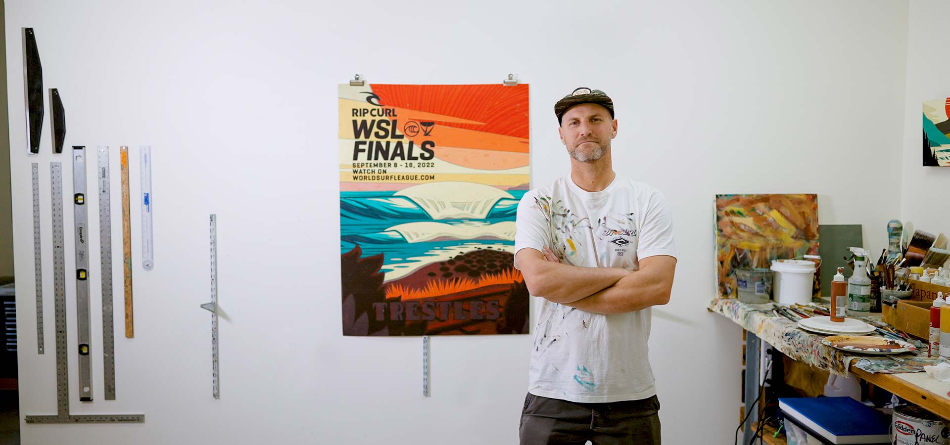 Rip Curl WSL Finals Artist Erik Abel standing in front of his artwork.