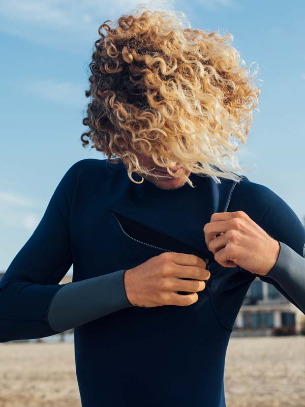 Rip Curl crew putting on a chest zip wetsuit