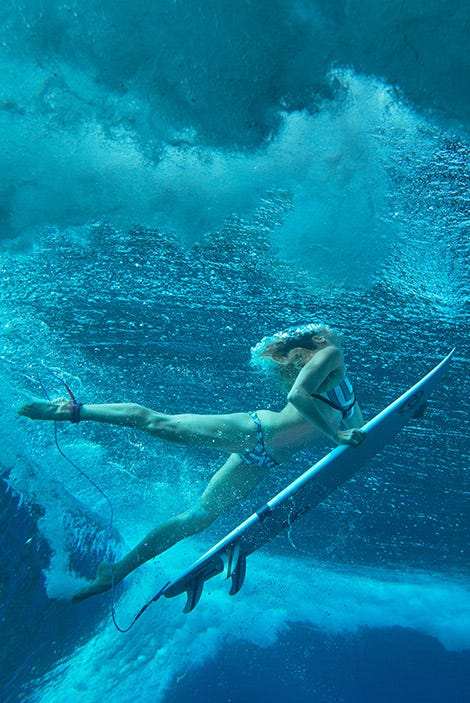 Rosy Hodge duck diving under a wave