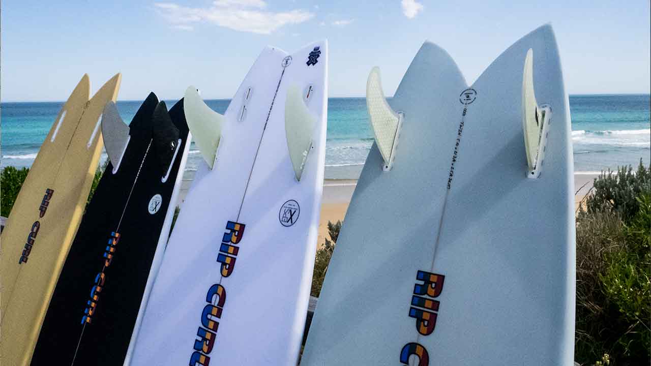 Rip Curl surfboards standing up against a fence