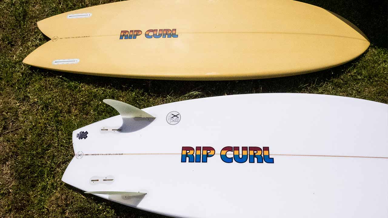 Rip Curl surf boards laying on the grass.