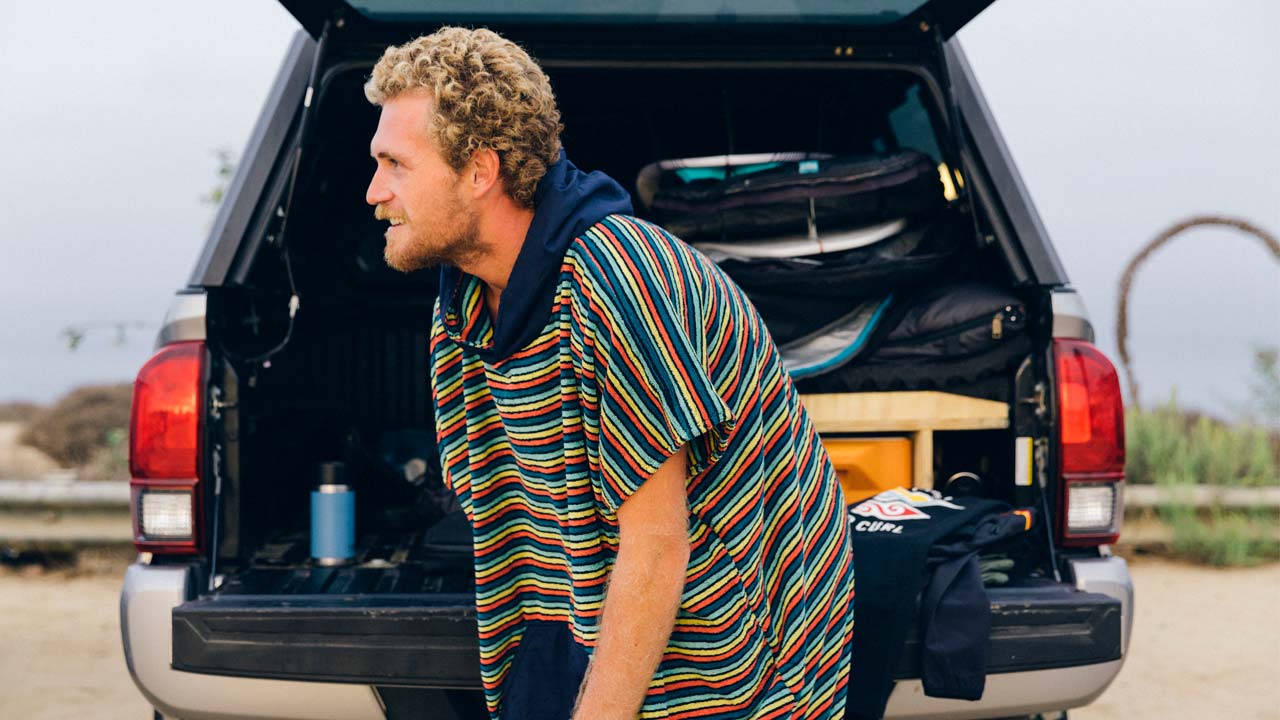 Rip Curl crew wears a stripey hooded towel