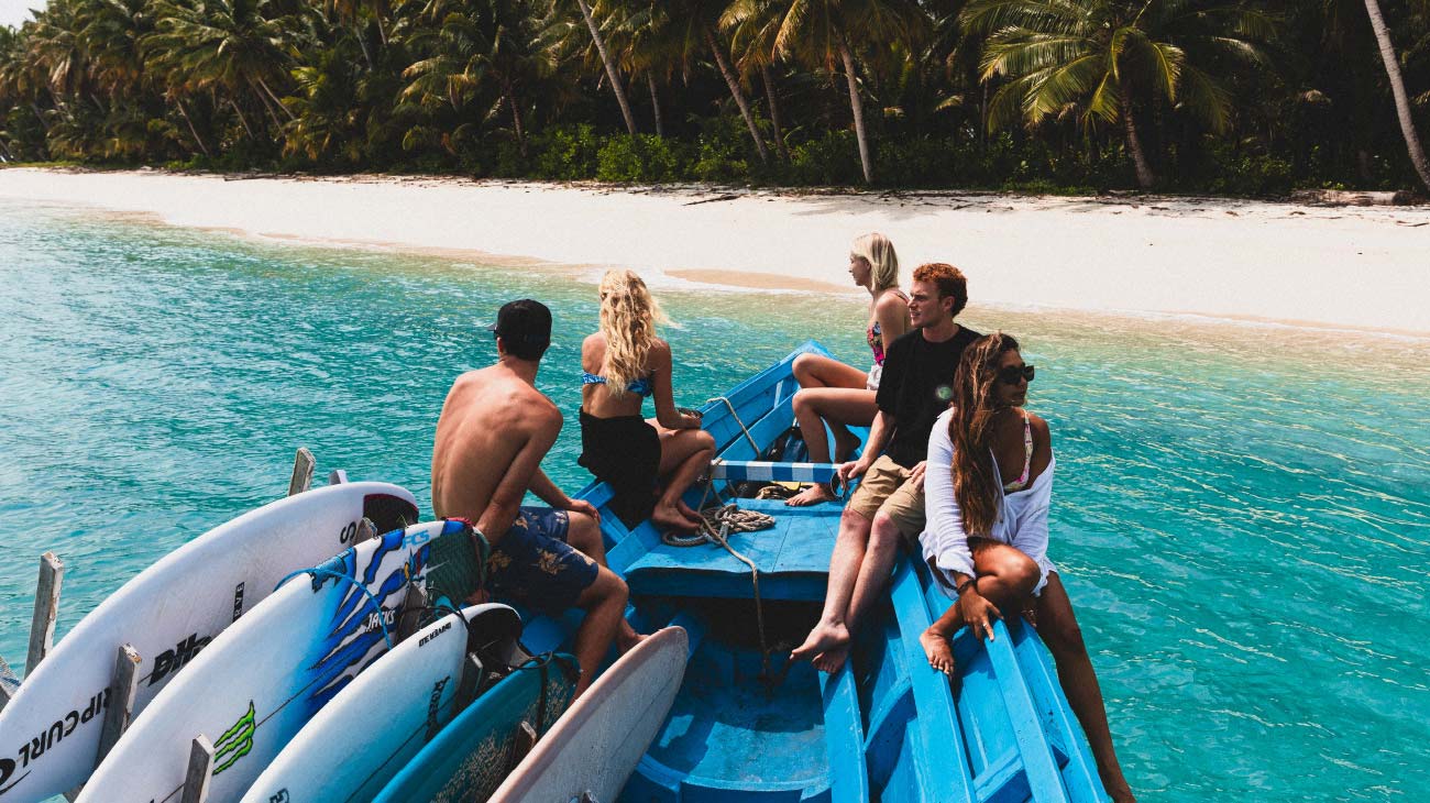 Crew sitting in a boat with their surfboards in the Mentawais