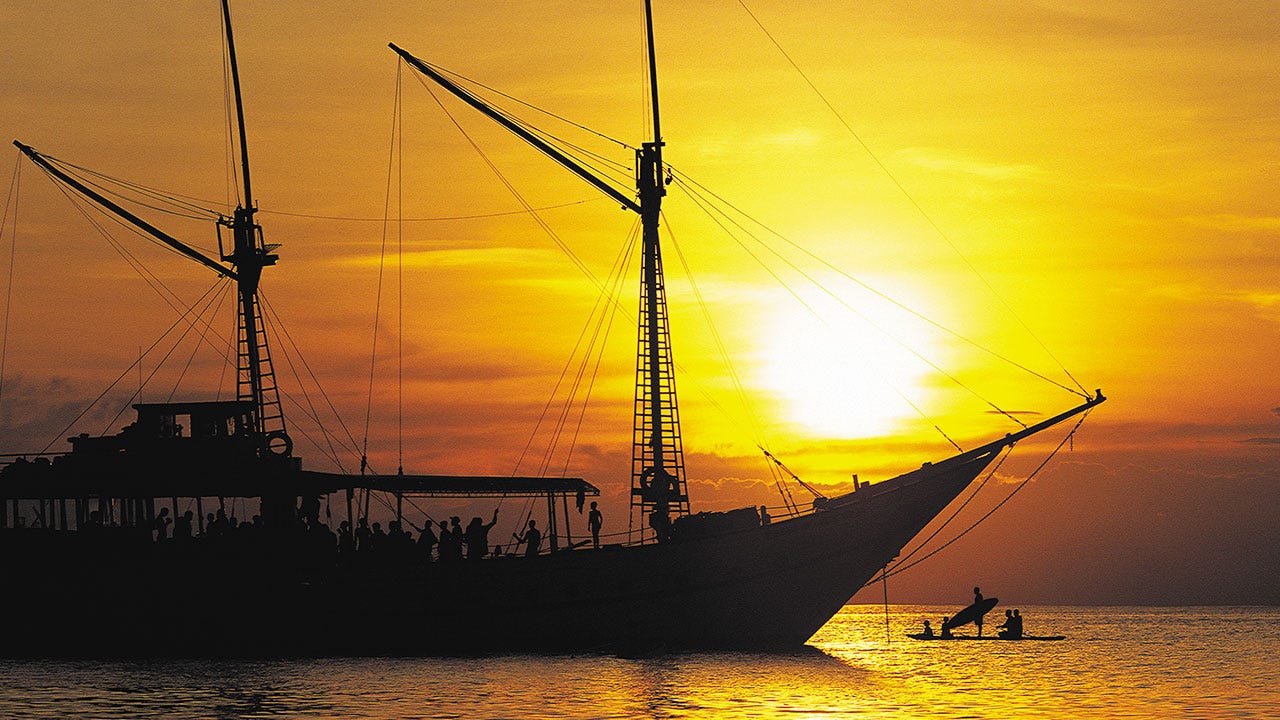 Silhouette image of womens boat on the ocean