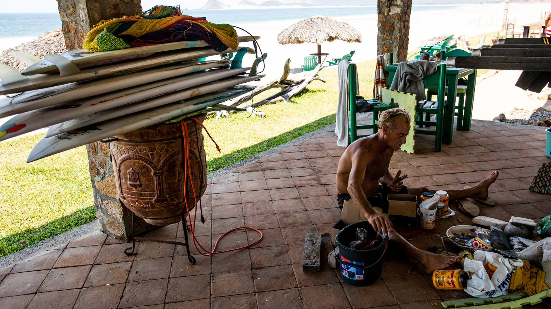 Tom Curren sitting on the ground painting