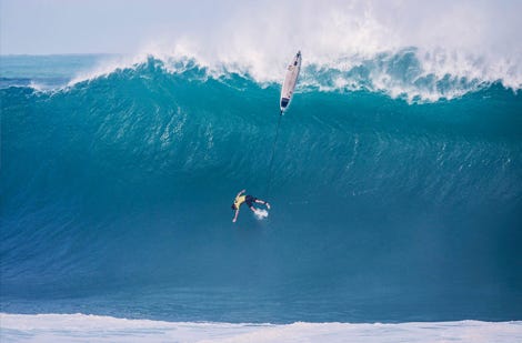 Male surfer coming off his board on a big wave