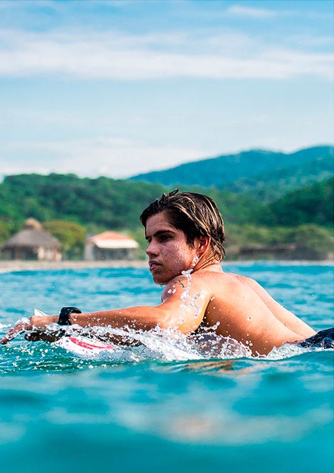 Close up image of Morgan Cibilic paddling out for a wave