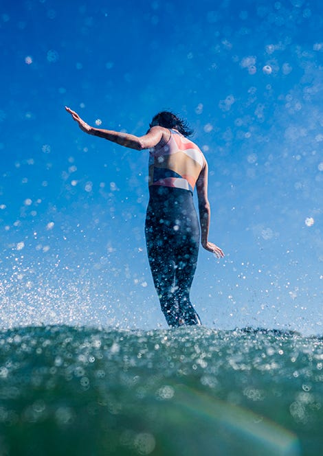 Back shot of Victoria Vergara surfing a longboard