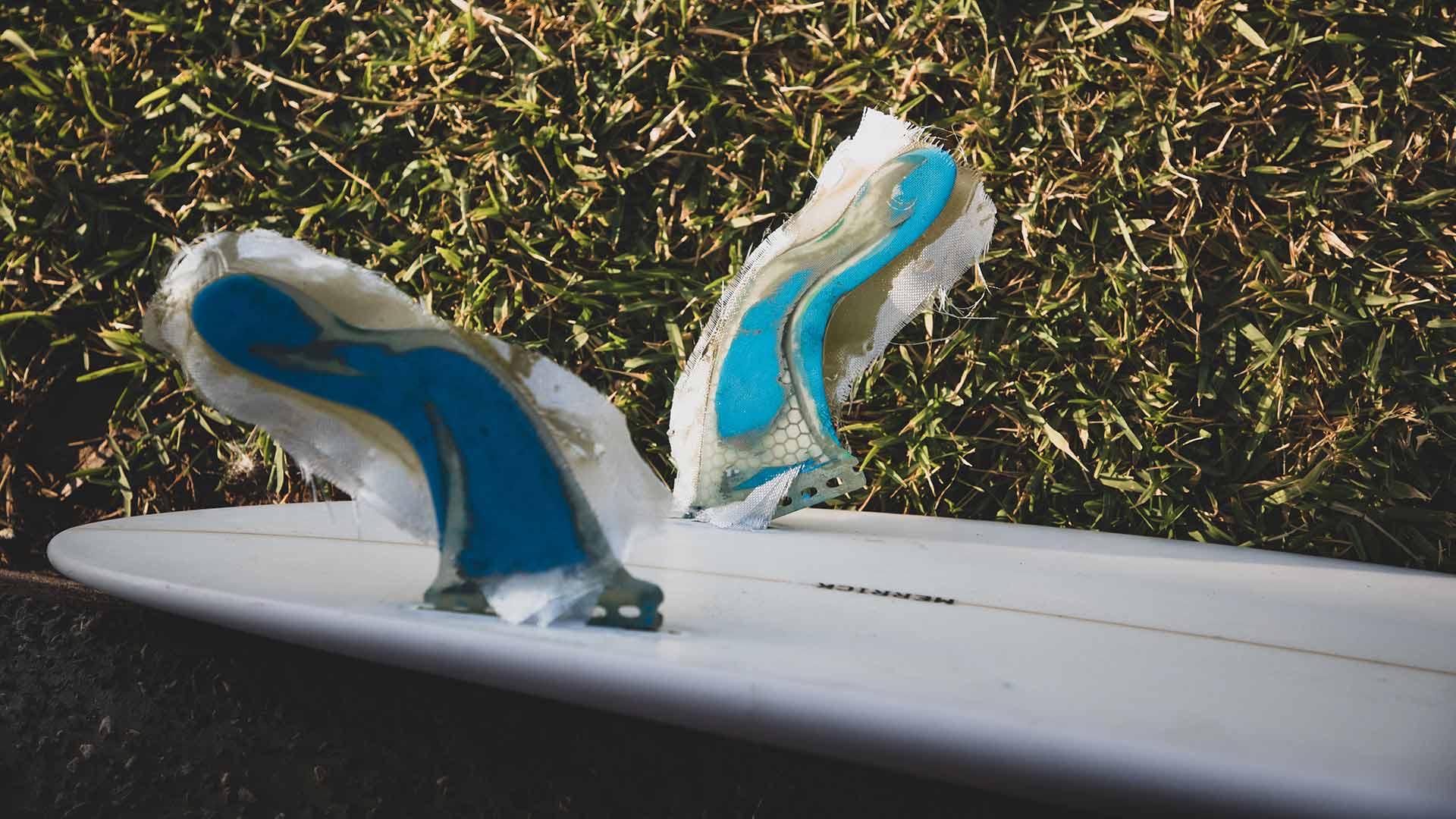 Close up image of the fins of his surfboard